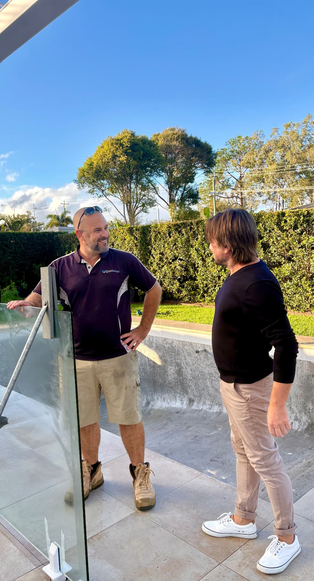 Glass Safe installer Paul discussing a frameless glass pool fence with a homeowner